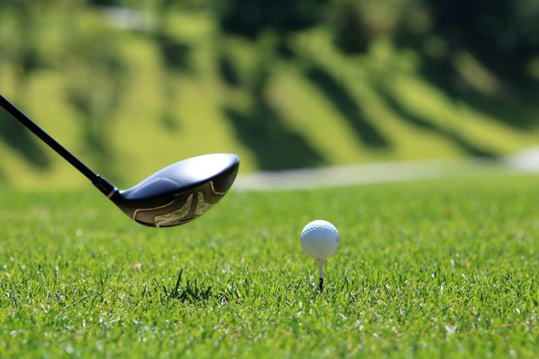 golf santo domingo, mazza che sta per colpire la pallina da golf bianca sul green, punto di rotta