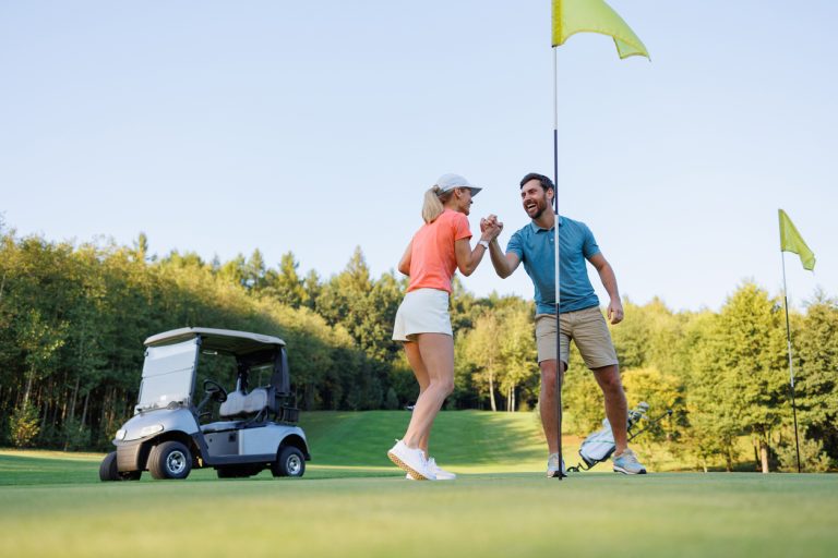 golf in repubblica dominicana, coppia che gioca sul green, punto di rotta